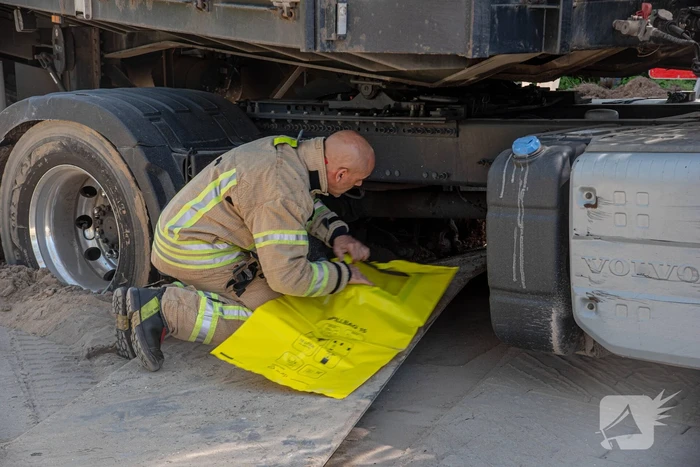 Vrachtwagen vast in het zand en verliest brandstof door lek