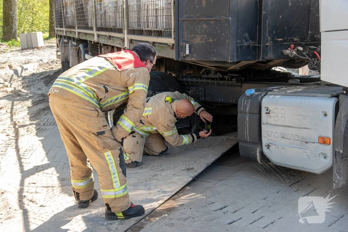 Vrachtwagen vast in het zand en verliest brandstof door lek