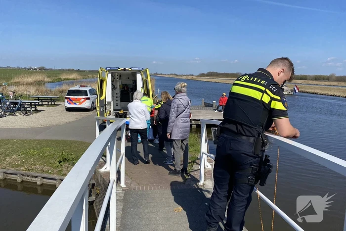 Vrouw kukelt met fiets van brug