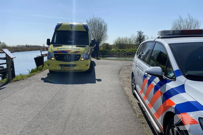Vrouw kukelt met fiets van brug