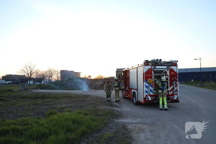 Brandweer blust brandende pallets