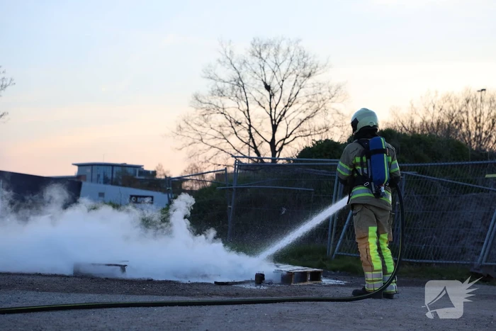 Brandweer blust brandende pallets