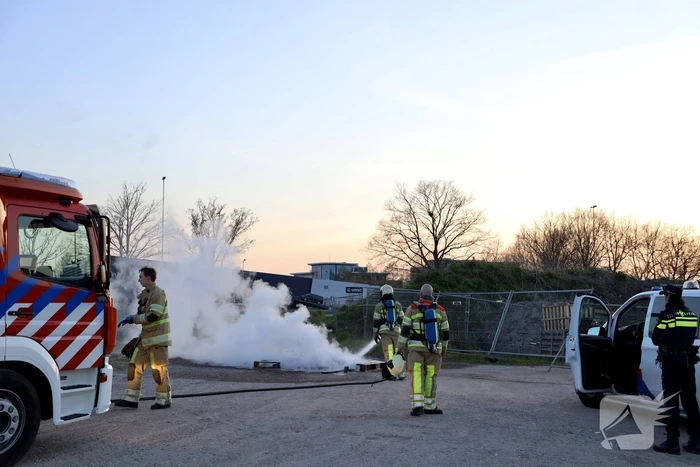 Brandweer blust brandende pallets