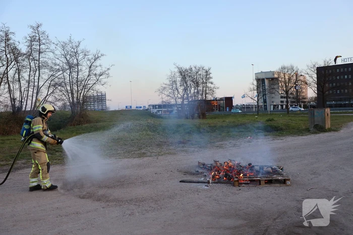 Brandweer blust brandende pallets