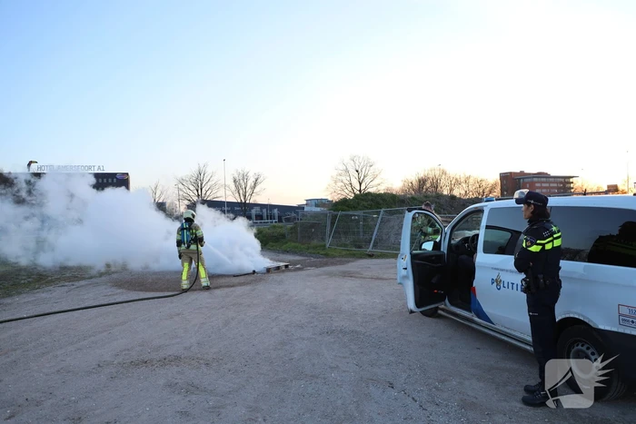 Brandweer blust brandende pallets