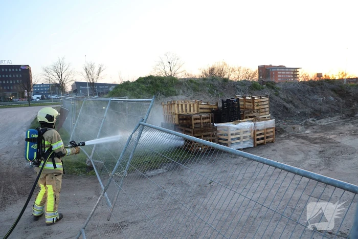 Brandweer blust brandende pallets
