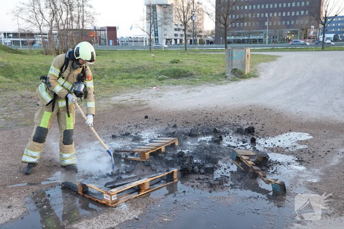 Brandweer blust brandende pallets