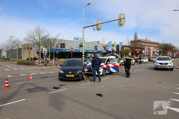 Politieauto met spoed ramt personenauto