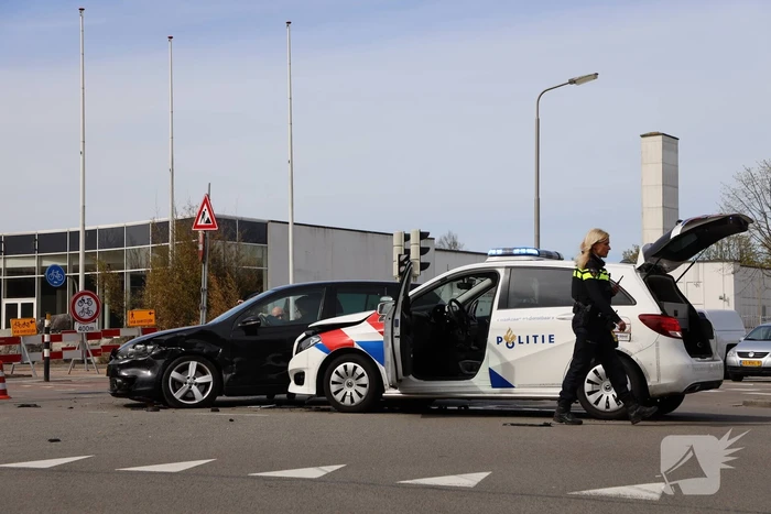 Politieauto met spoed ramt personenauto