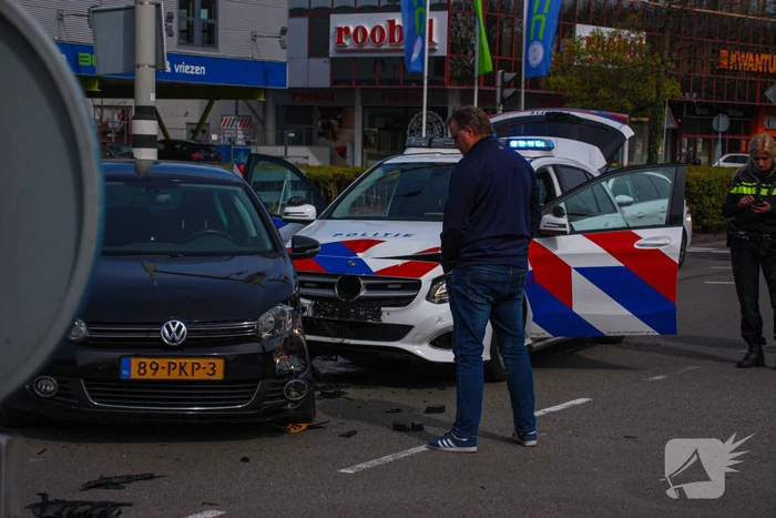 Politieauto met spoed ramt personenauto