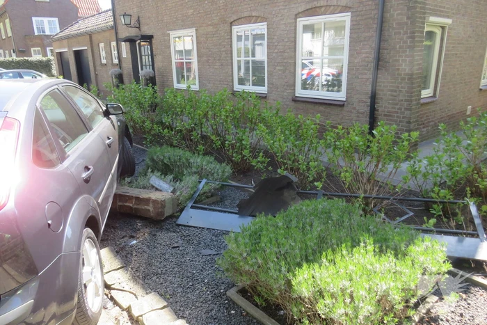 Bestuurder rijdt met auto op tuinhek