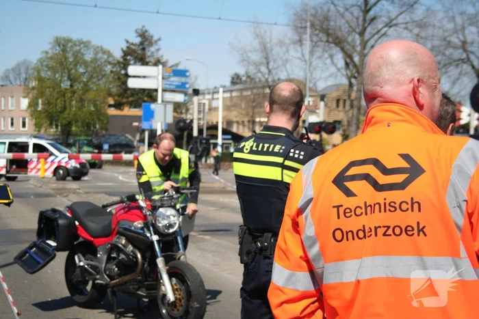Motor heeft veel schade door botsing met personenauto en trein