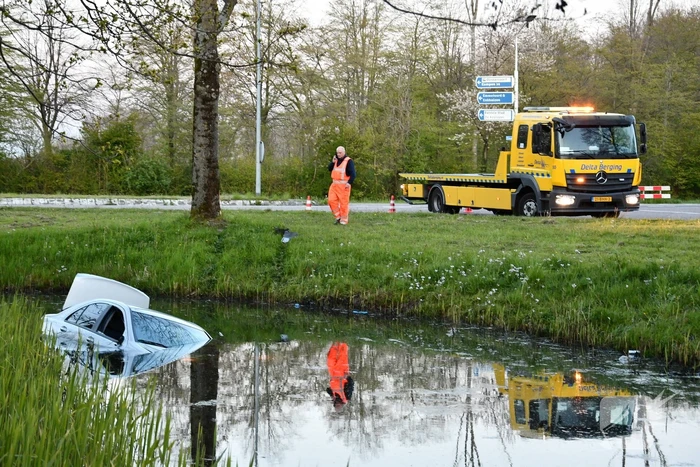 Auto rijdt diepe sloot in