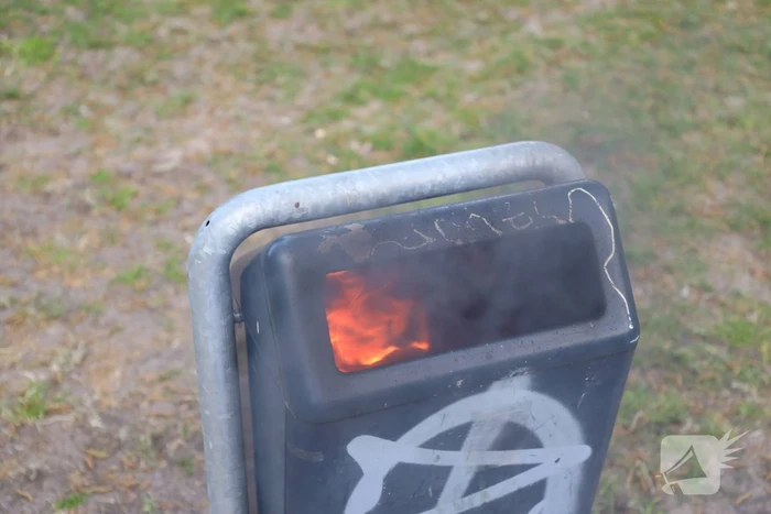 Brandweer blust brand in afvalcontainer