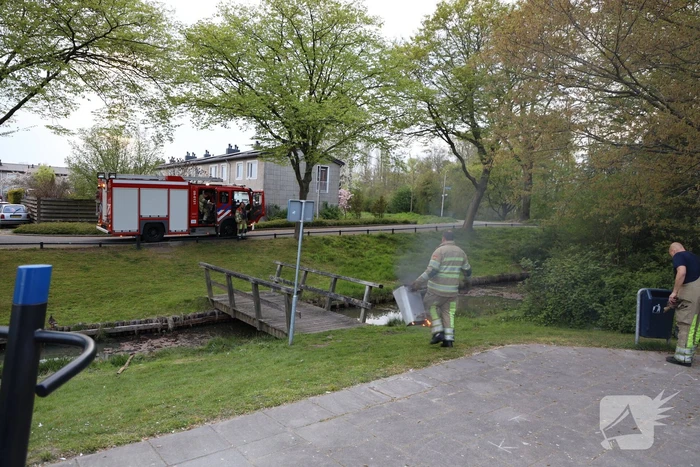 Brandweer blust brand in afvalcontainer