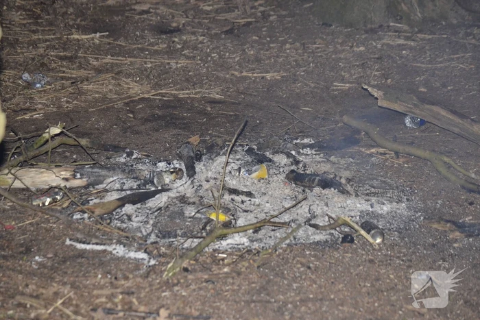 Brandweer blust kampvuur met emmers water