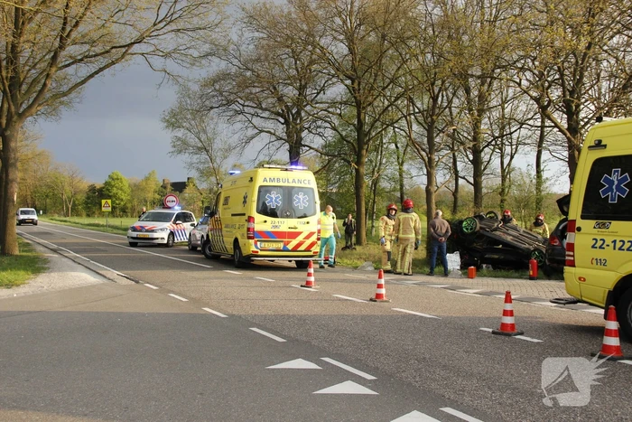 Personenauto ondersteboven door botsing