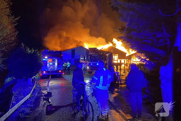 Brandweer bestrijdt grote uitslaande brand in twee loodsen