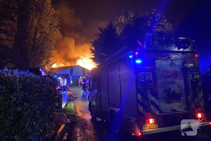 Brandweer bestrijdt grote uitslaande brand in twee loodsen