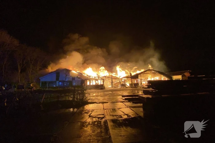 Brandweer bestrijdt grote uitslaande brand in twee loodsen