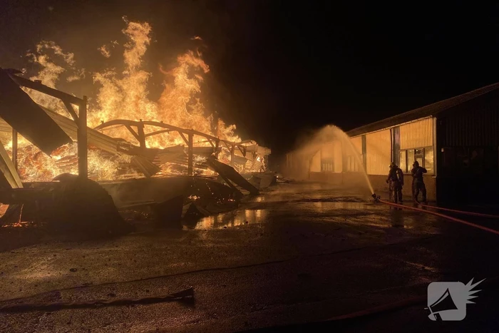 Brandweer bestrijdt grote uitslaande brand in twee loodsen
