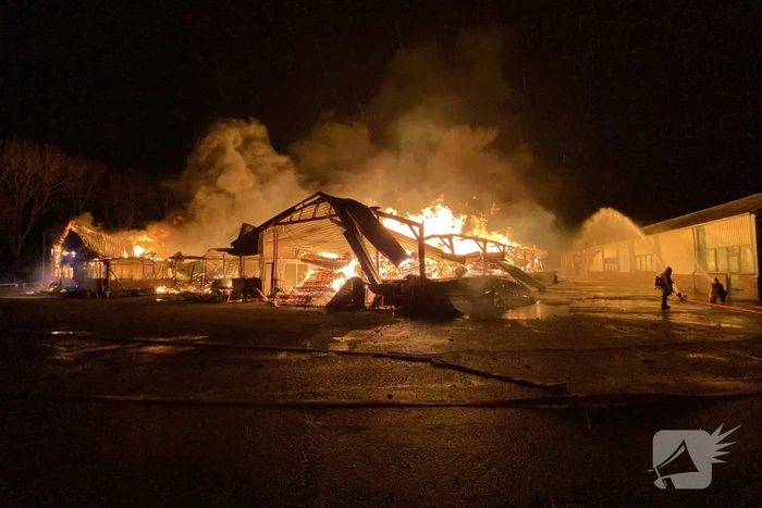 Brandweer bestrijdt grote uitslaande brand in twee loodsen