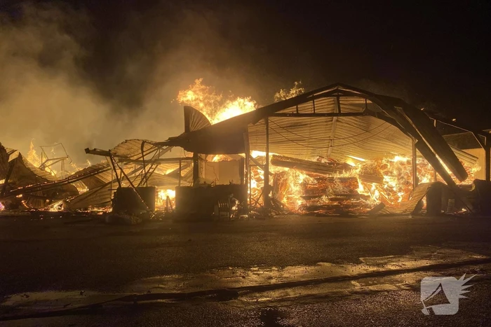 Brandweer bestrijdt grote uitslaande brand in twee loodsen