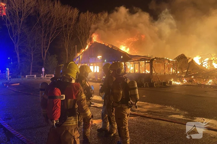 Brandweer bestrijdt grote uitslaande brand in twee loodsen