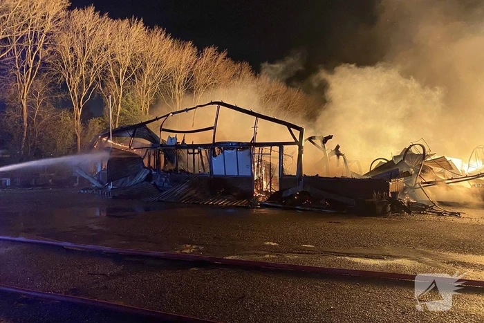 Brandweer bestrijdt grote uitslaande brand in twee loodsen