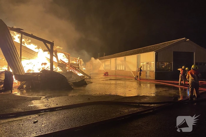 Brandweer bestrijdt grote uitslaande brand in twee loodsen