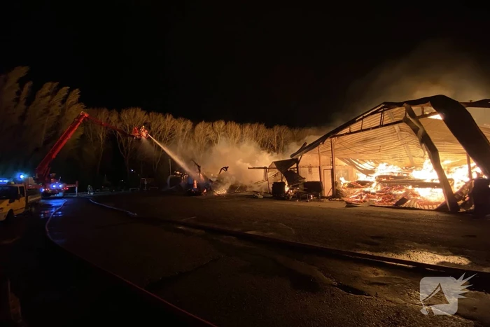 Brandweer bestrijdt grote uitslaande brand in twee loodsen