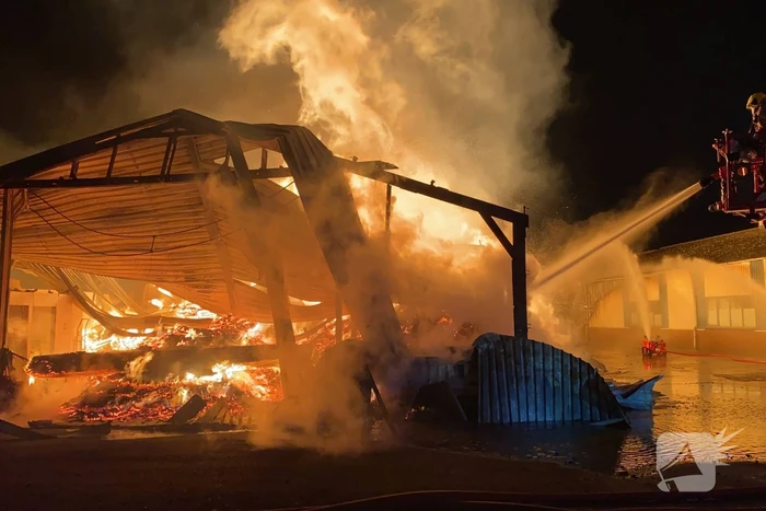 Brandweer bestrijdt grote uitslaande brand in twee loodsen