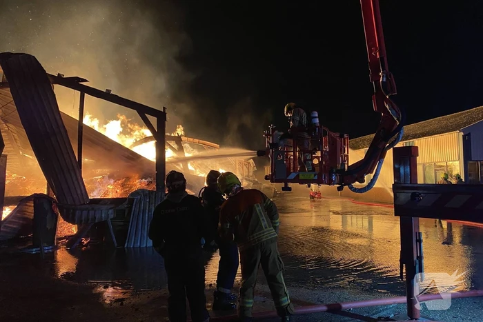 Brandweer bestrijdt grote uitslaande brand in twee loodsen