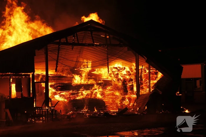Brandweer bestrijdt grote uitslaande brand in twee loodsen