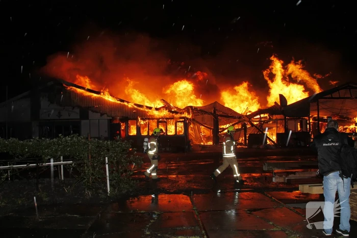 Brandweer bestrijdt grote uitslaande brand in twee loodsen