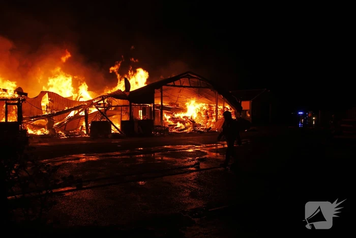 Brandweer bestrijdt grote uitslaande brand in twee loodsen