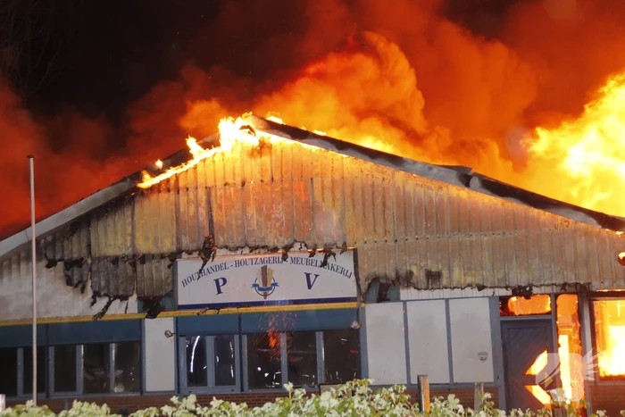 Brandweer bestrijdt grote uitslaande brand in twee loodsen