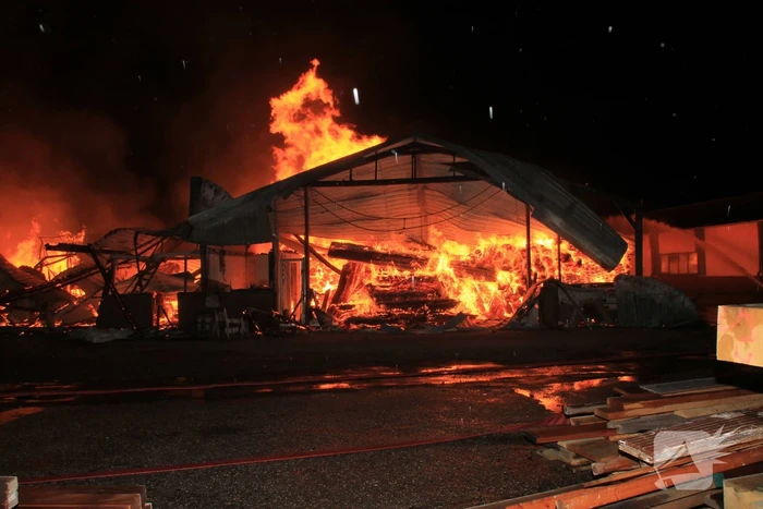 Brandweer bestrijdt grote uitslaande brand in twee loodsen