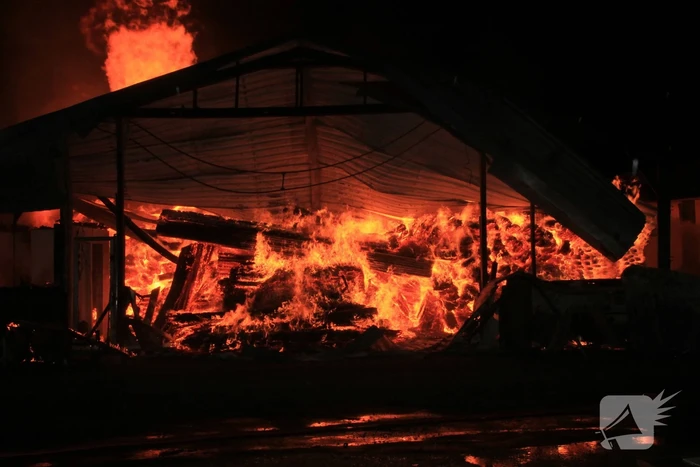 Brandweer bestrijdt grote uitslaande brand in twee loodsen