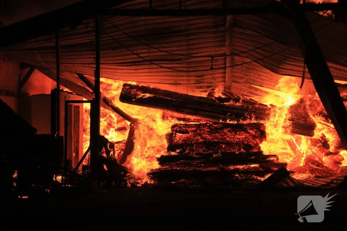 Brandweer bestrijdt grote uitslaande brand in twee loodsen