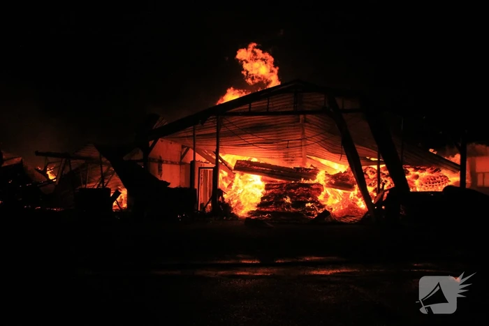 Brandweer bestrijdt grote uitslaande brand in twee loodsen