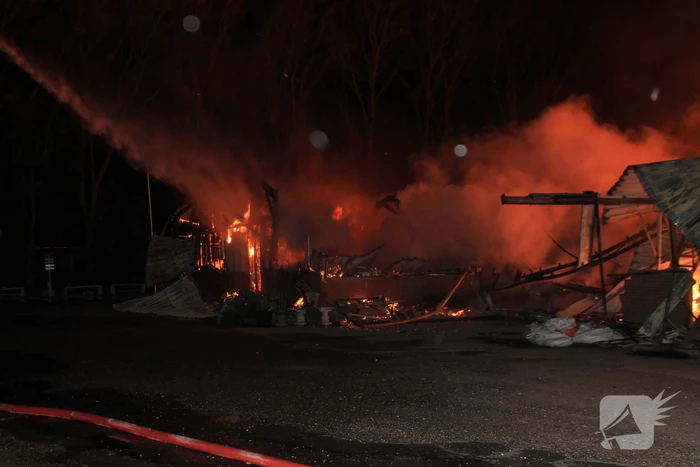 Brandweer bestrijdt grote uitslaande brand in twee loodsen