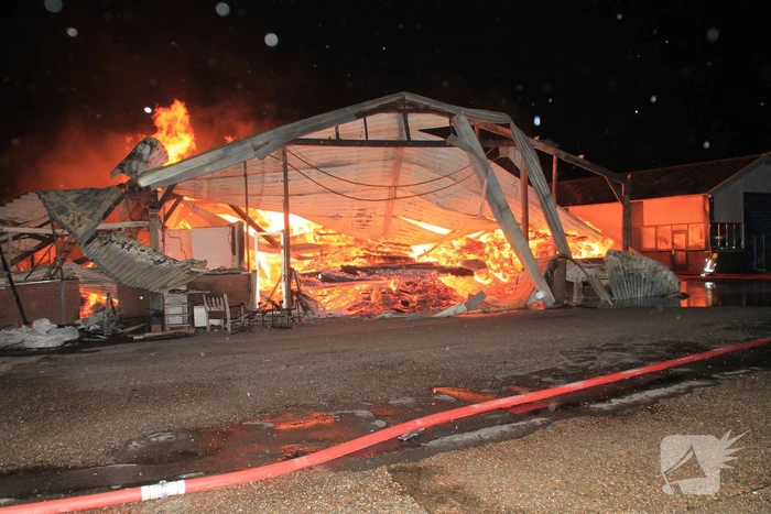 Brandweer bestrijdt grote uitslaande brand in twee loodsen