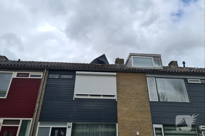Dakbedekking waait van dakkapel van woning