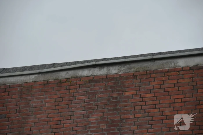 Brandweer boort schroeven in bijna loskomende dakrand