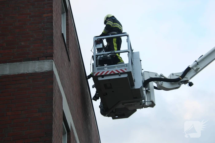 Brandweer boort schroeven in bijna loskomende dakrand
