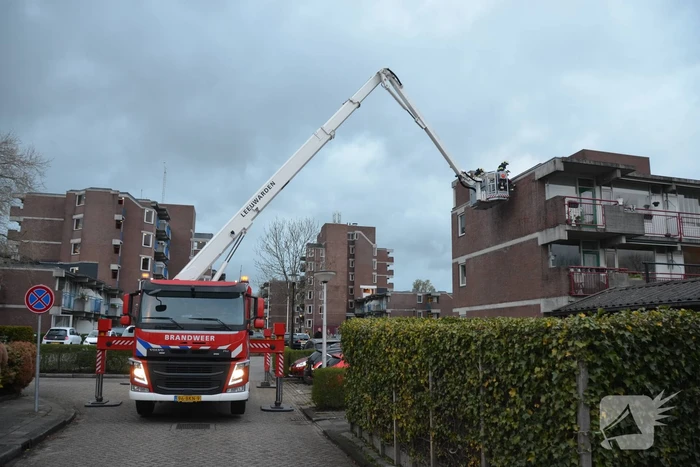 Brandweer boort schroeven in bijna loskomende dakrand