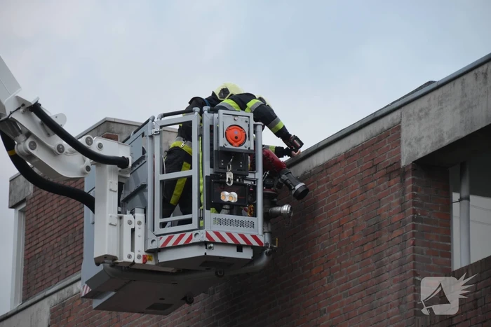Brandweer boort schroeven in bijna loskomende dakrand