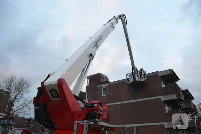 Brandweer boort schroeven in bijna loskomende dakrand