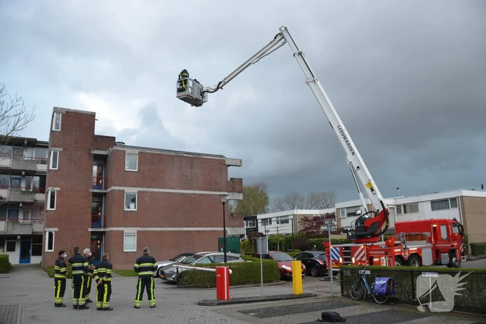 Brandweer boort schroeven in bijna loskomende dakrand